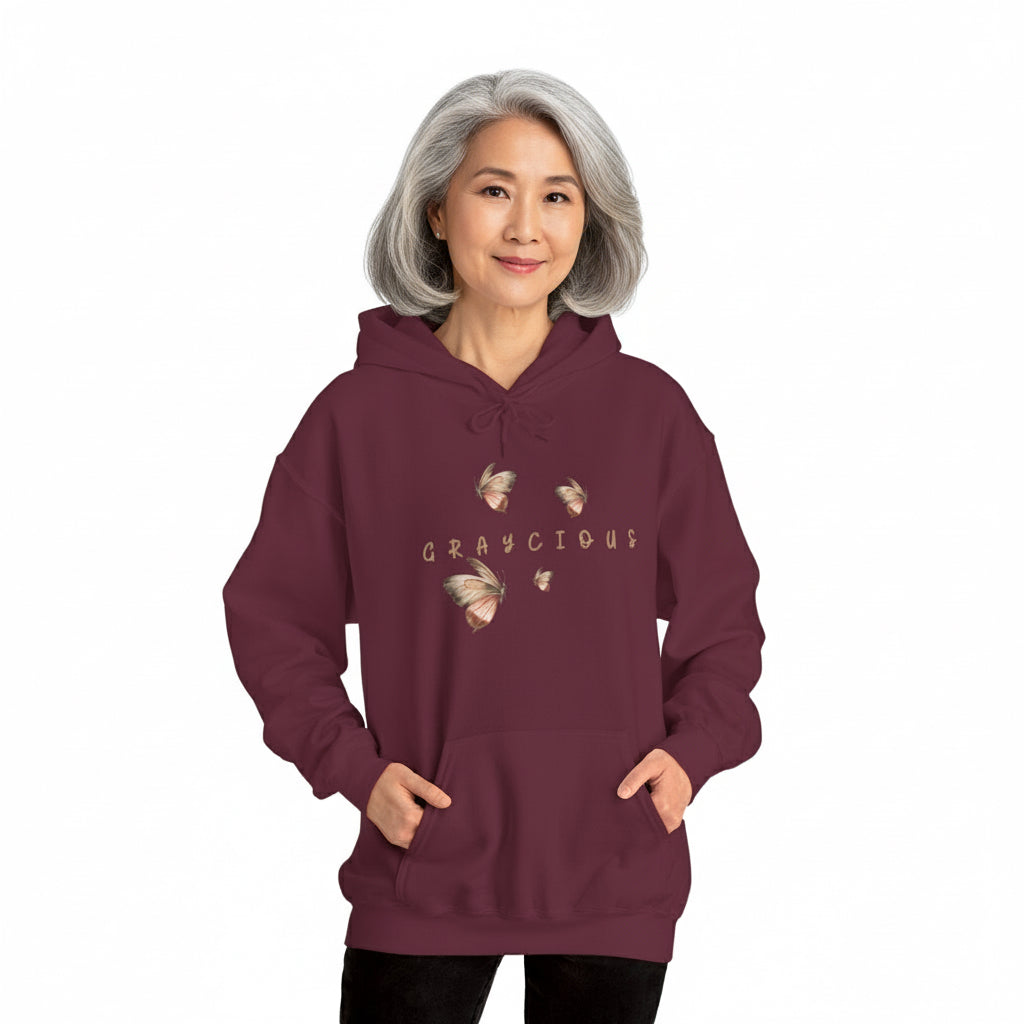 Person wearing a maroon hoodie with graphic designs and text on a white background