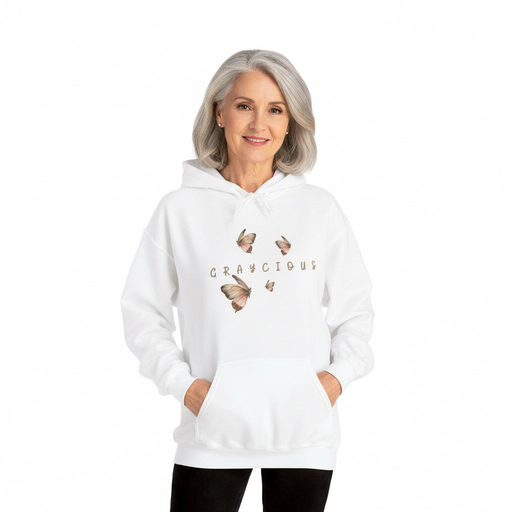 Person wearing a white hoodie with butterfly designs and text on a white background
