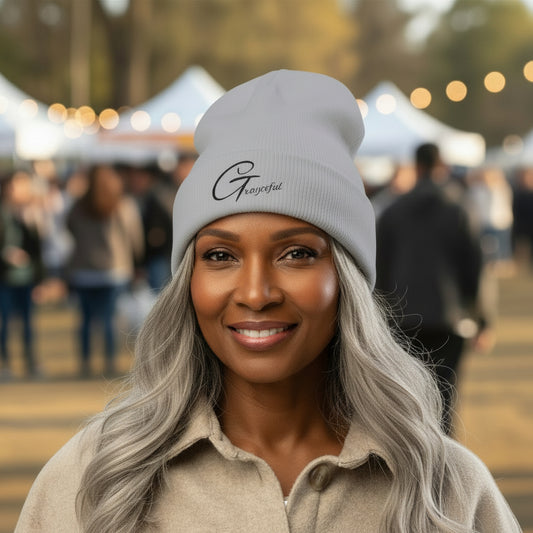 Woman wearing a gray beanie with a logo at an outdoor event